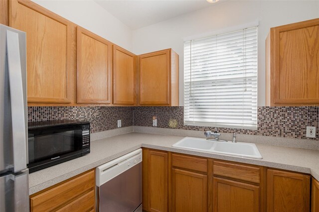 13521 Forest Lake Dr, Largo, FL 33771 - kitchen with dishwashing machine, black microwave, a sink, and light countertops