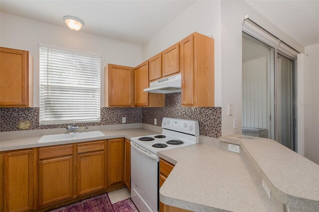 13521 Forest Lake Dr, Largo, FL 33771 - kitchen featuring white electric stove, under cabinet range hood, a sink, light countertops, and decorative backsplash
