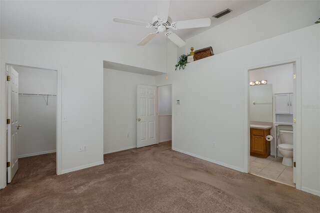13521 Forest Lake Dr, Largo, FL 33771 - unfurnished bedroom featuring light carpet, a walk in closet, baseboards, a closet, and connected bathroom