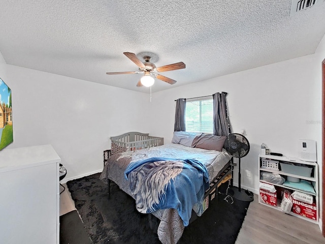 13094 Huntington Woods Ave, Spring Hill, FL 34609 - bedroom featuring wood finished floors, ceiling fan, a textured ceiling, and baseboards