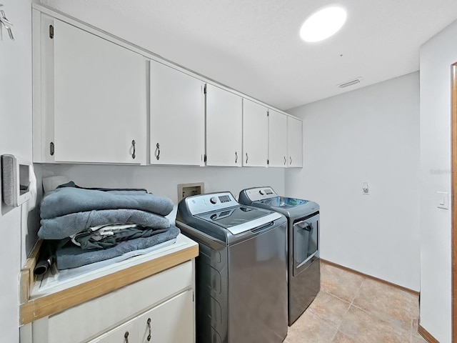 13094 Huntington Woods Ave, Spring Hill, FL 34609 - laundry room with cabinet space, washer and clothes dryer, baseboards, and light tile patterned floors
