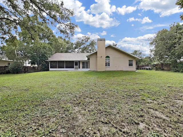 13094 Huntington Woods Ave, Spring Hill, FL 34609 - rear view of house featuring a chimney, a sunroom, and stucco siding