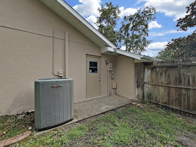 13094 Huntington Woods Ave, Spring Hill, FL 34609 - view of exterior entry with central AC unit and stucco siding