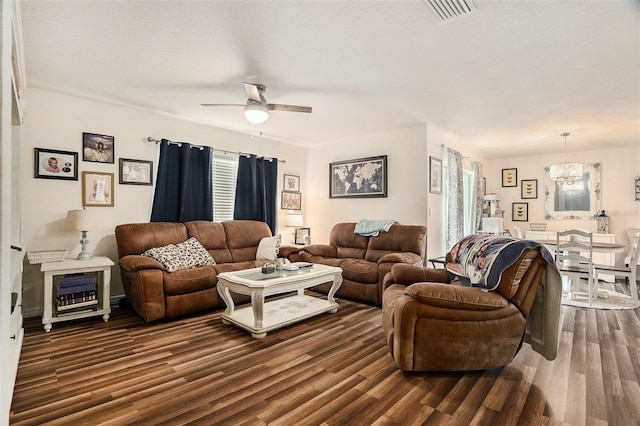 7639 Broad Pointe Dr, Zephyrhills, FL 33540 - living room with a ceiling fan, a chandelier, dark wood-style floors, and healthy amount of natural light