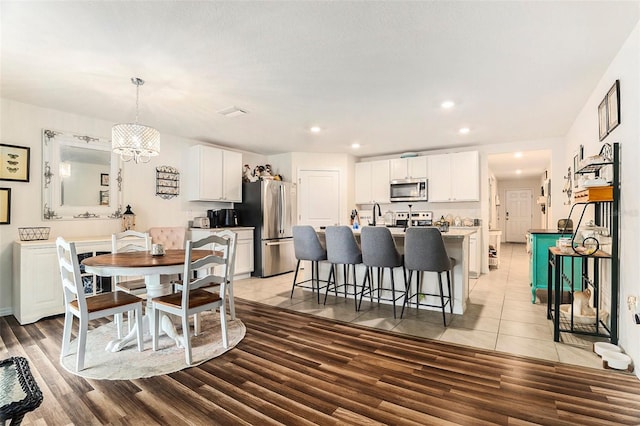 7639 Broad Pointe Dr, Zephyrhills, FL 33540 - dining area with light wood-type flooring, a chandelier, and recessed lighting
