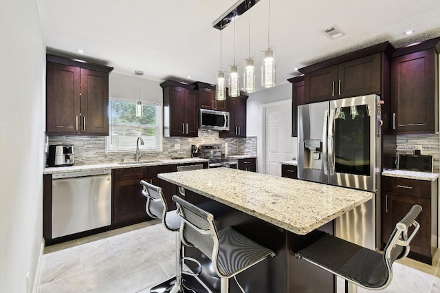 229 Temple Ave, Fern Park, FL 32730 - kitchen featuring stainless steel appliances, a sink, decorative backsplash, a kitchen bar, and recessed lighting