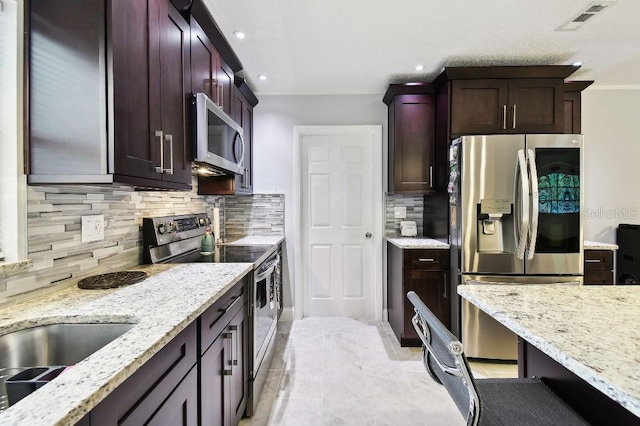 229 Temple Ave, Fern Park, FL 32730 - kitchen with appliances with stainless steel finishes, light stone counters, recessed lighting, backsplash, and a sink