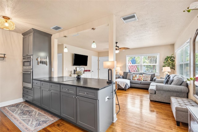 2709 Upton St S, Gulfport, FL 33711 - kitchen featuring open floor plan, gray cabinets, dark countertops, a textured ceiling, and double oven