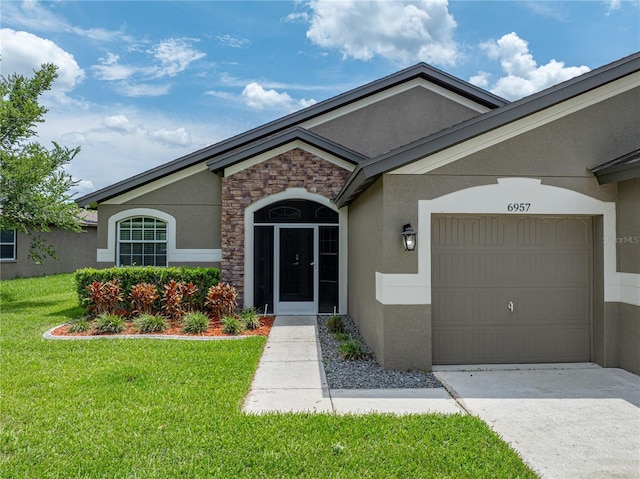 6957 Boulder Run Loop, Wesley Chapel, FL 33545 - doorway to property featuring stucco siding, a yard, an attached garage, stone siding, and driveway