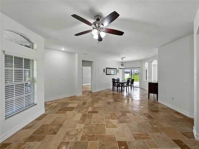 6957 Boulder Run Loop, Wesley Chapel, FL 33545 - unfurnished room with stone tile floors, ceiling fan, baseboards, and a chandelier
