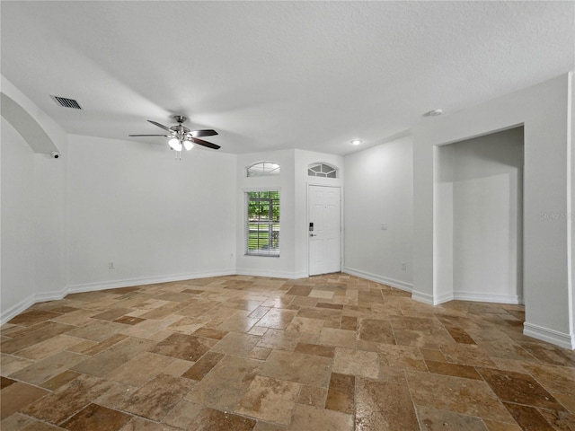 6957 Boulder Run Loop, Wesley Chapel, FL 33545 - foyer entrance featuring stone tile flooring, ceiling fan, and baseboards