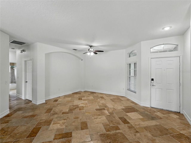6957 Boulder Run Loop, Wesley Chapel, FL 33545 - foyer with stone tile flooring, ceiling fan, and baseboards