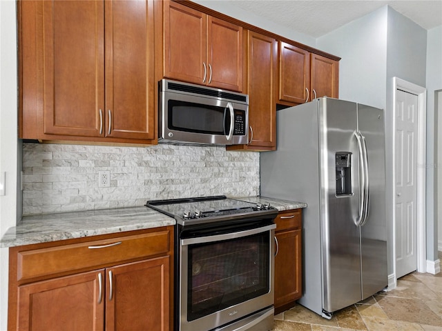 6957 Boulder Run Loop, Wesley Chapel, FL 33545 - kitchen with stainless steel appliances, decorative backsplash, brown cabinetry, and light stone countertops