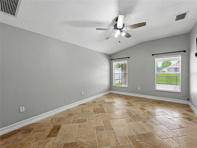 6957 Boulder Run Loop, Wesley Chapel, FL 33545 - unfurnished room with stone tile floors, a ceiling fan, vaulted ceiling, and baseboards