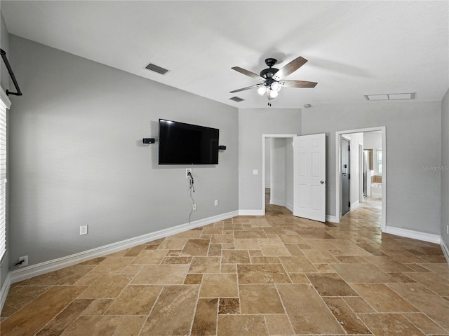 6957 Boulder Run Loop, Wesley Chapel, FL 33545 - unfurnished bedroom with stone tile floors, ensuite bathroom, baseboards, and ceiling fan