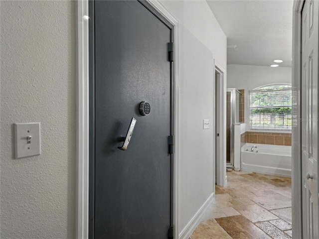 6957 Boulder Run Loop, Wesley Chapel, FL 33545 - bathroom with stone tile flooring, a bath, and baseboards