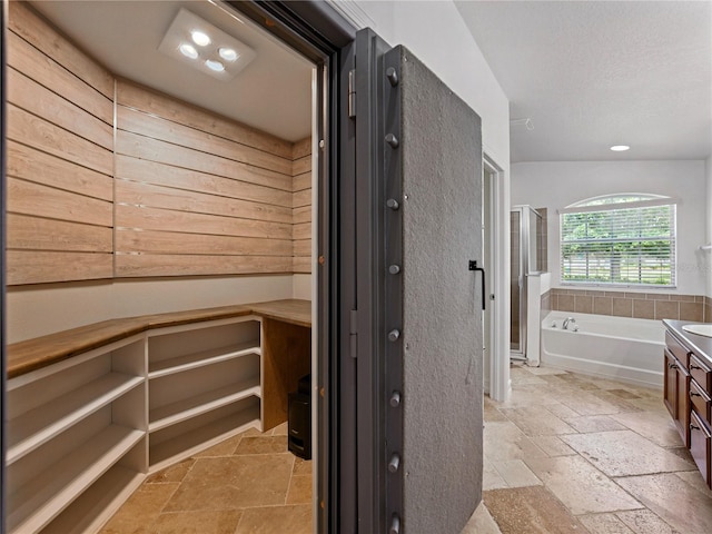 6957 Boulder Run Loop, Wesley Chapel, FL 33545 - full bath with a closet, stone tile floors, a bath, a shower stall, and vanity