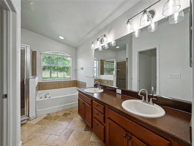 6957 Boulder Run Loop, Wesley Chapel, FL 33545 - bathroom with a shower stall, double vanity, a garden tub, a textured ceiling, and stone tile flooring