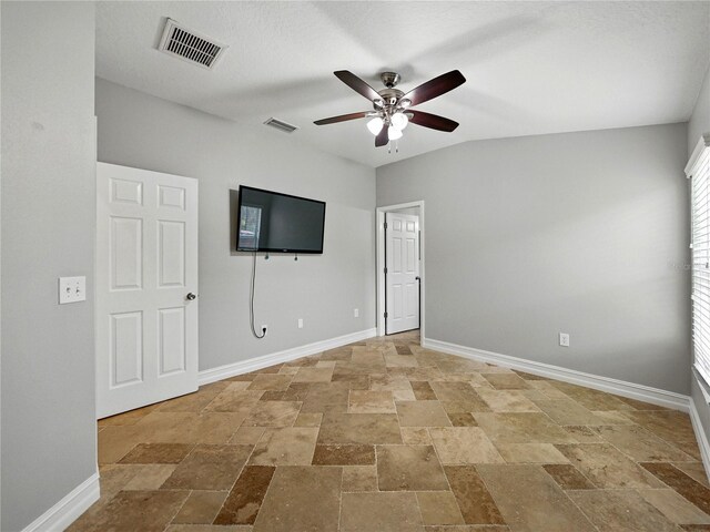 6957 Boulder Run Loop, Wesley Chapel, FL 33545 - unfurnished bedroom with stone tile floors, baseboards, and ceiling fan