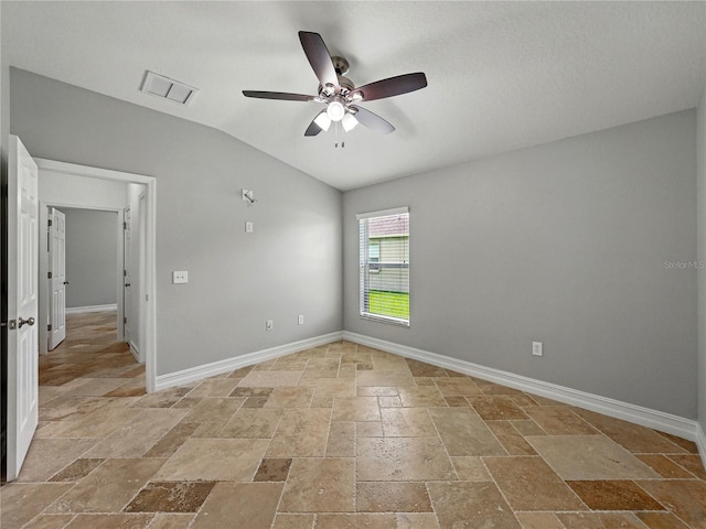 6957 Boulder Run Loop, Wesley Chapel, FL 33545 - spare room with stone tile floors, a ceiling fan, vaulted ceiling, and baseboards