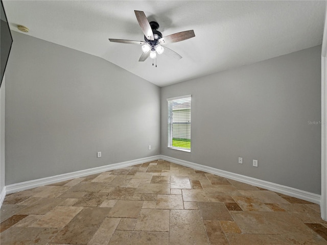6957 Boulder Run Loop, Wesley Chapel, FL 33545 - unfurnished room with stone tile floors, lofted ceiling, baseboards, a ceiling fan, and a smoke detector