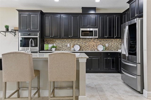 18696 Malinche Loop, Spring Hill, FL 34610 - kitchen featuring stainless steel appliances, dark cabinetry, tasteful backsplash, light stone countertops, and recessed lighting