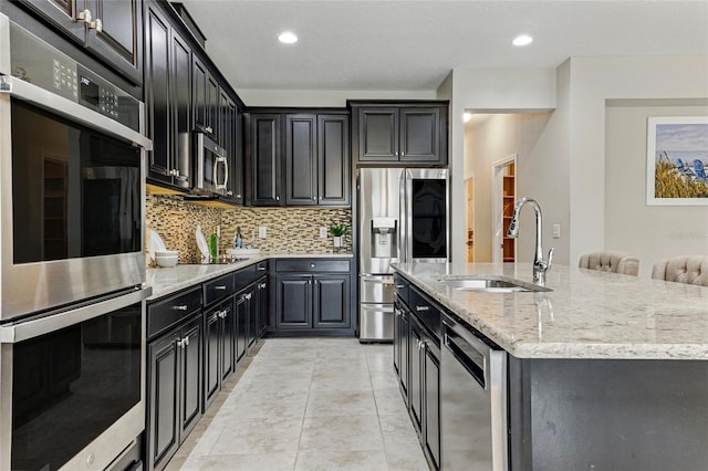 18696 Malinche Loop, Spring Hill, FL 34610 - kitchen featuring stainless steel appliances, a sink, decorative backsplash, dark cabinets, and recessed lighting