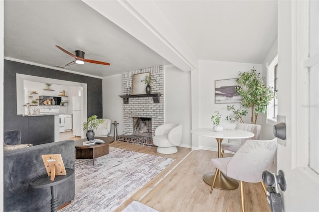 5622 Tangerine Ave S, Gulfport, FL 33707 - living area featuring a fireplace, wood finished floors, ceiling fan, ornamental molding, and baseboards