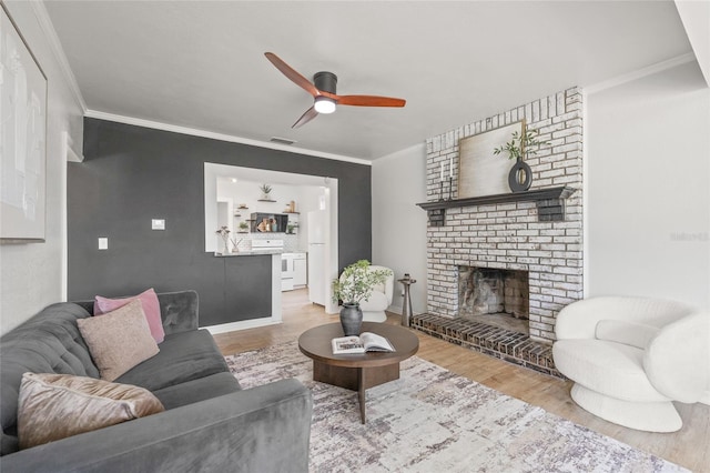 5622 Tangerine Ave S, Gulfport, FL 33707 - living room with ceiling fan, crown molding, wood finished floors, and a fireplace