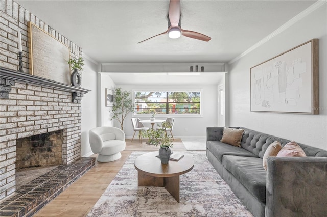 5622 Tangerine Ave S, Gulfport, FL 33707 - living room with wood finished floors, ornamental molding, ceiling fan, a brick fireplace, and baseboards