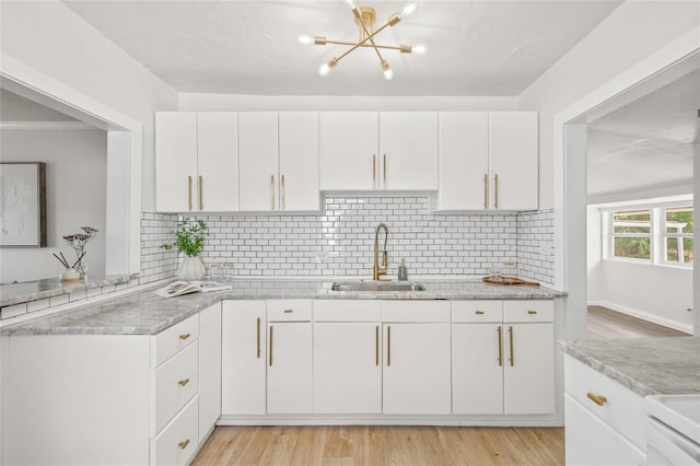 5622 Tangerine Ave S, Gulfport, FL 33707 - kitchen featuring a sink, a chandelier, white cabinets, and decorative backsplash