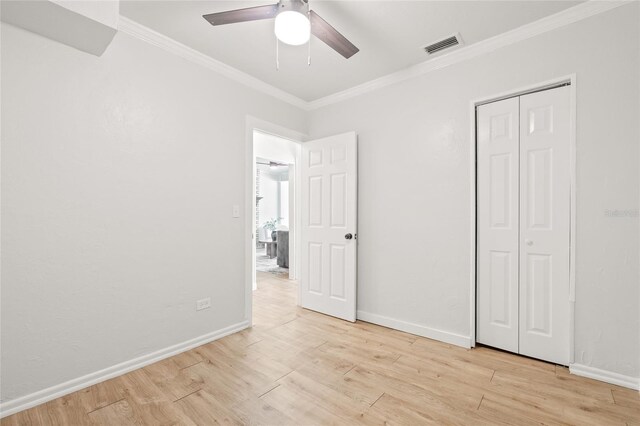 5622 Tangerine Ave S, Gulfport, FL 33707 - unfurnished bedroom with crown molding, light wood-type flooring, baseboards, a ceiling fan, and a closet