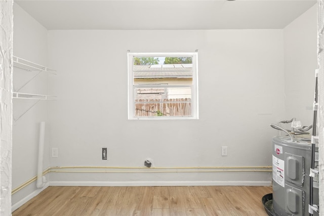 5622 Tangerine Ave S, Gulfport, FL 33707 - laundry room with light wood finished floors, water heater, and baseboards