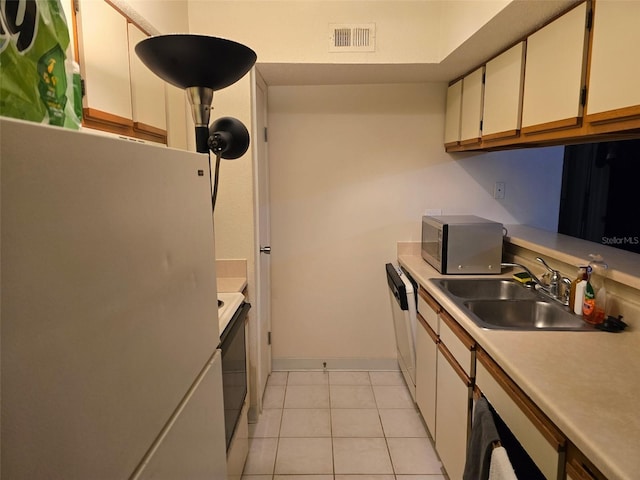 9100 Mlk St N Unit 503, Saint Petersburg, FL 33702 - kitchen with white appliances, a sink, light countertops, white cabinets, and light tile patterned floors