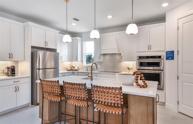 1576 Valier Pt, Zephyrhills, FL 33541 - kitchen featuring appliances with stainless steel finishes, custom exhaust hood, tasteful backsplash, light countertops, and recessed lighting