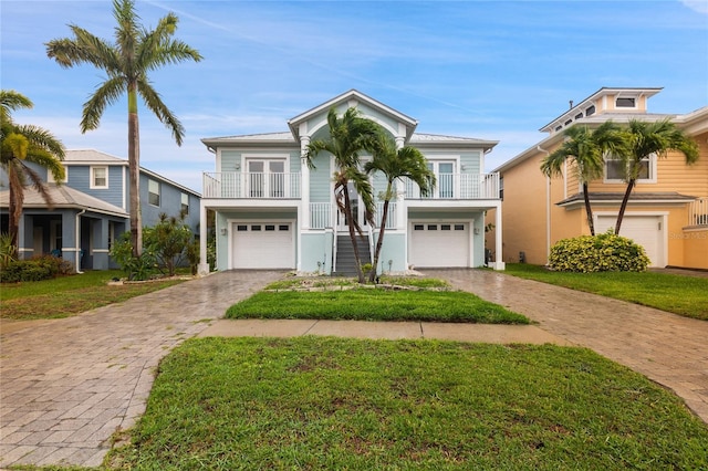 6416 Grenada Island Ave, Apollo Beach, FL 33572 - coastal inspired home with stairway, an attached garage, driveway, and a front lawn