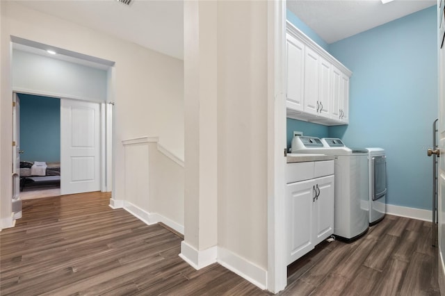 6416 Grenada Island Ave, Apollo Beach, FL 33572 - laundry room with dark wood-style flooring, independent washer and dryer, cabinet space, and baseboards