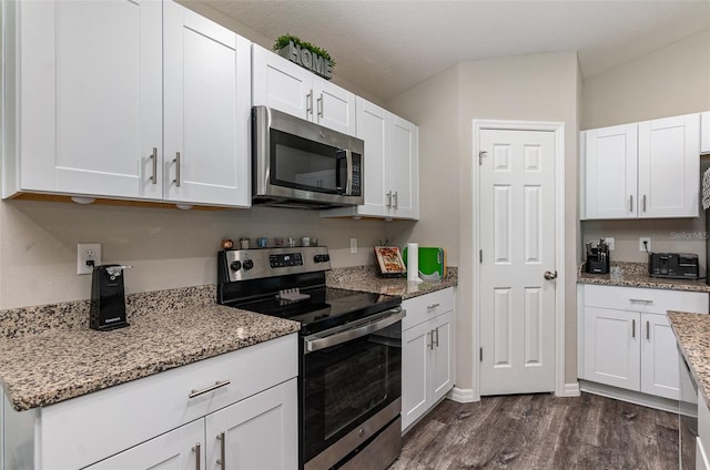 1368 Axel Cir, Winter Haven, FL 33880 - kitchen with appliances with stainless steel finishes, white cabinets, dark wood-style flooring, and light stone counters