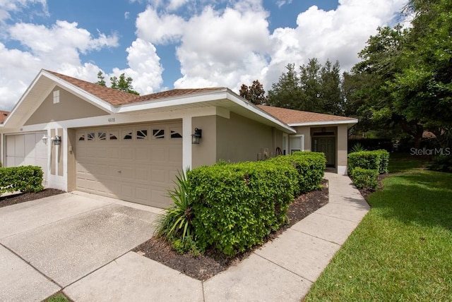4228 Silver Star Dr, Spring Hill, FL 34609 - view of front facade featuring stucco siding, concrete driveway, a garage, and a front yard
