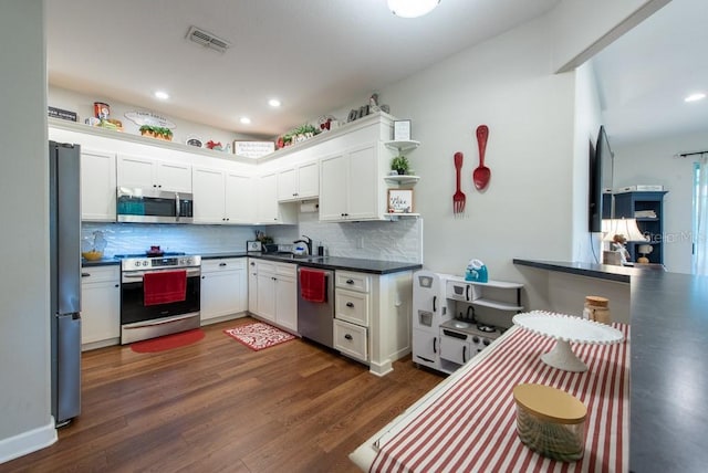 4228 Silver Star Dr, Spring Hill, FL 34609 - kitchen with stainless steel appliances, backsplash, dark wood finished floors, dark countertops, and white cabinetry