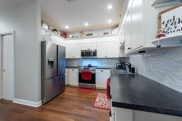 4228 Silver Star Dr, Spring Hill, FL 34609 - kitchen with appliances with stainless steel finishes, a sink, dark countertops, dark wood-style floors, and recessed lighting