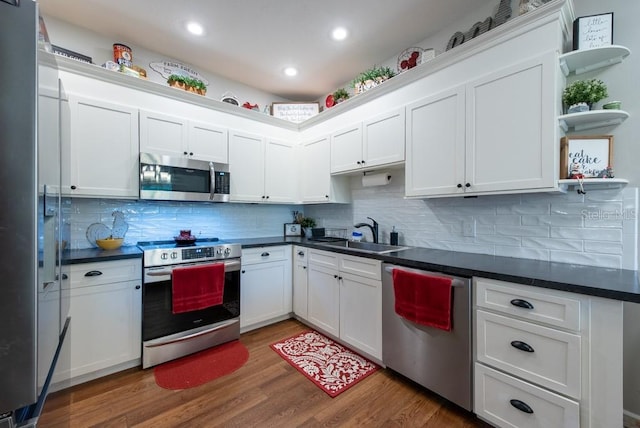 4228 Silver Star Dr, Spring Hill, FL 34609 - kitchen with appliances with stainless steel finishes, a sink, dark countertops, white cabinets, and recessed lighting