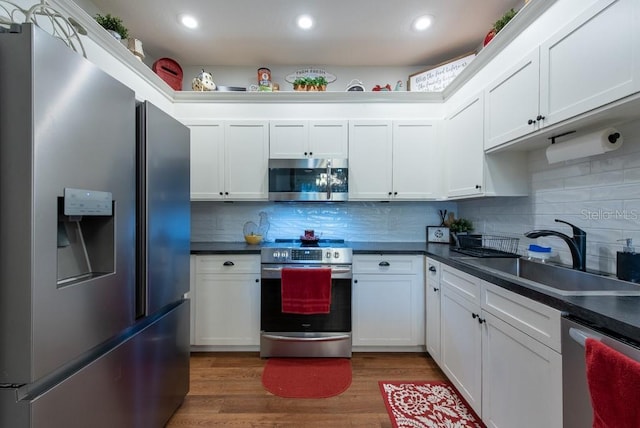 4228 Silver Star Dr, Spring Hill, FL 34609 - kitchen featuring appliances with stainless steel finishes, a sink, dark countertops, backsplash, and white cabinets