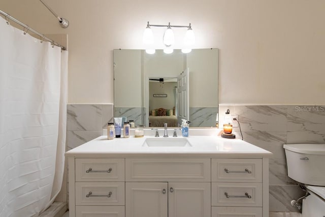 4228 Silver Star Dr, Spring Hill, FL 34609 - ensuite bathroom with tile walls, toilet, vanity, a wainscoted wall, and curtained shower