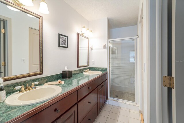 4783 Palermo Ct NE, Saint Petersburg, FL 33703 - full bath featuring double vanity, a shower stall, tile patterned flooring, and a textured ceiling
