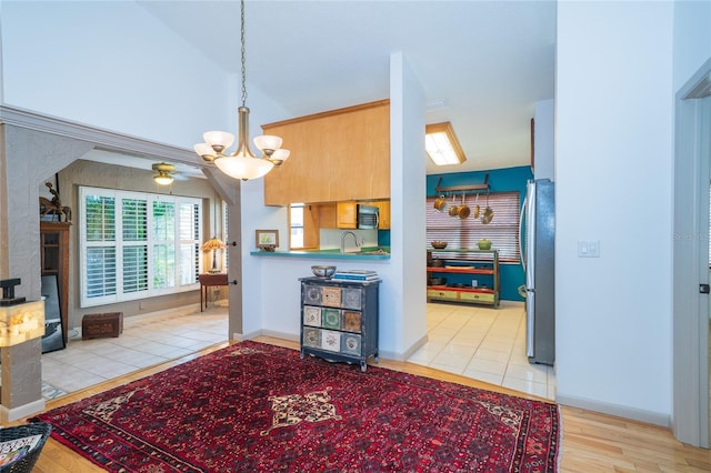 4783 Palermo Ct NE, Saint Petersburg, FL 33703 - kitchen featuring freestanding refrigerator, a chandelier, light wood finished floors, pendant lighting, and a sink
