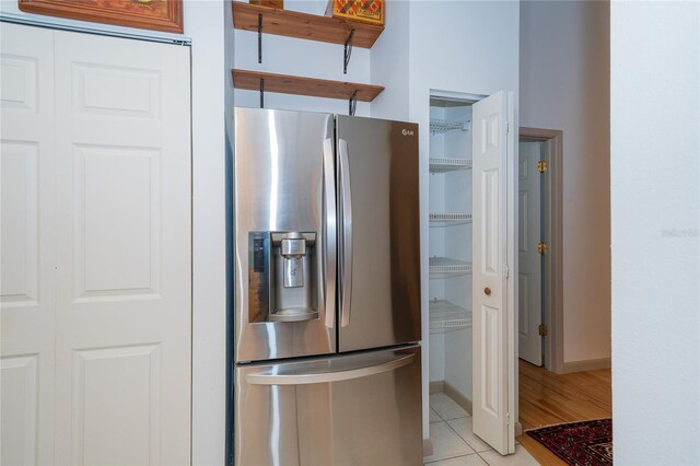 4783 Palermo Ct NE, Saint Petersburg, FL 33703 - kitchen featuring stainless steel refrigerator with ice dispenser, light tile patterned floors, open shelves, and baseboards