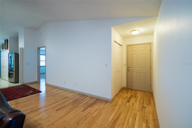 4783 Palermo Ct NE, Saint Petersburg, FL 33703 - unfurnished living room featuring light wood-style flooring, lofted ceiling, and baseboards