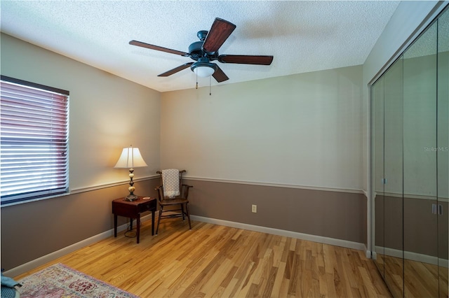 4783 Palermo Ct NE, Saint Petersburg, FL 33703 - living area featuring light wood-style flooring, ceiling fan, a textured ceiling, and baseboards