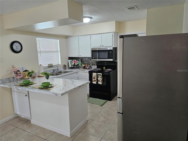 505 Innergary Pl, Valrico, FL 33594 - kitchen featuring appliances with stainless steel finishes, a peninsula, light countertops, light tile patterned flooring, and a textured ceiling